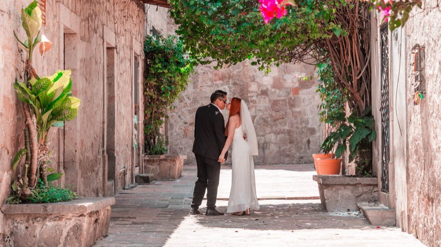 Beso bajo una bugambilia en un callejón de Morelia